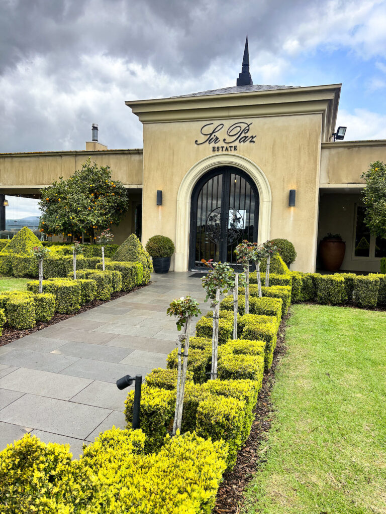 external view of sir paz estate yarra valley, an italianate building, path lined with small hedges